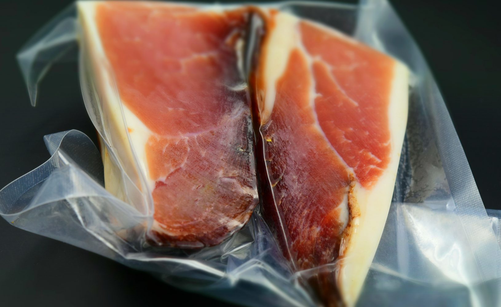A big piece of Italian speck in vacuum packing. Tilt-shift effect applied.